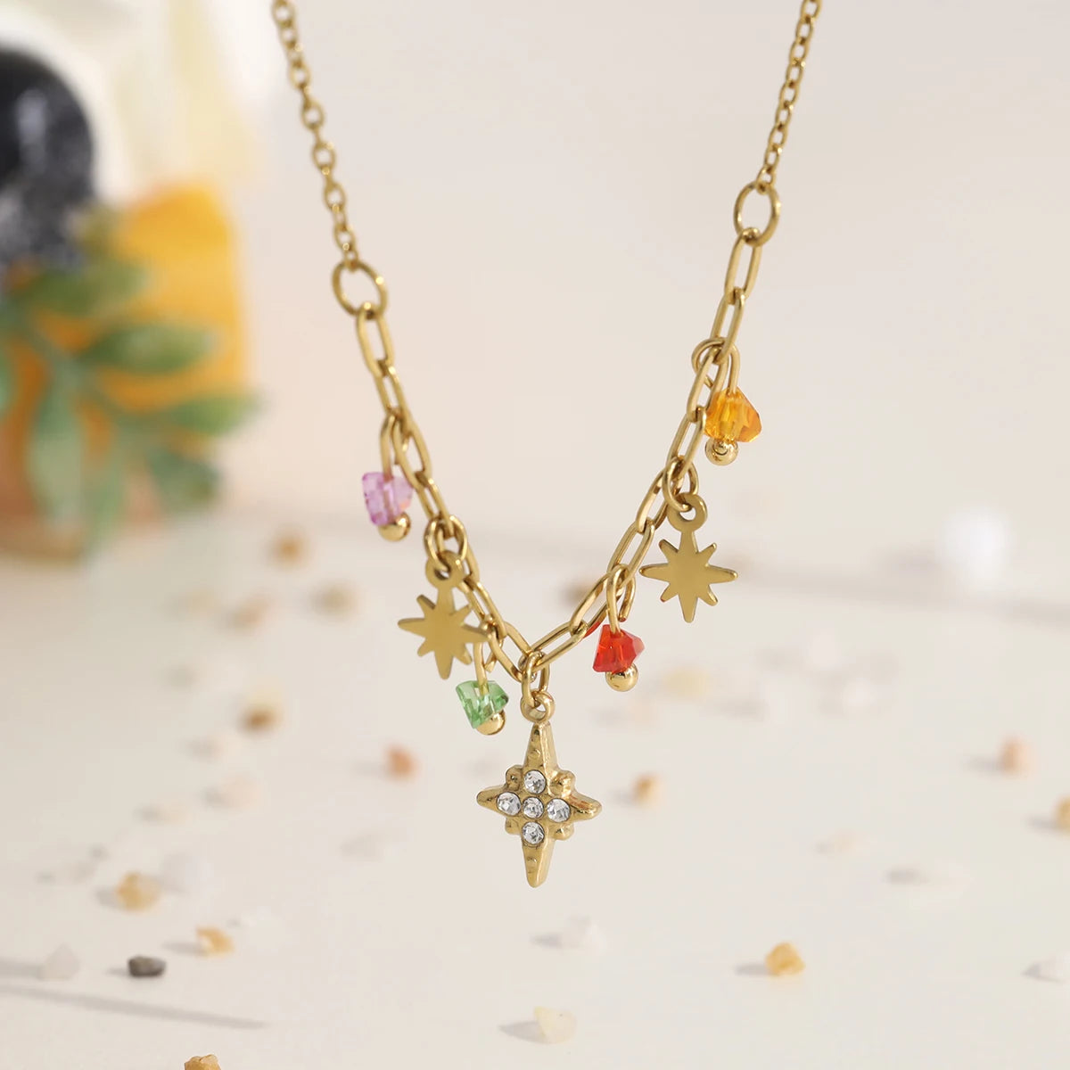 Gold necklace with star-shaped charms on a light background