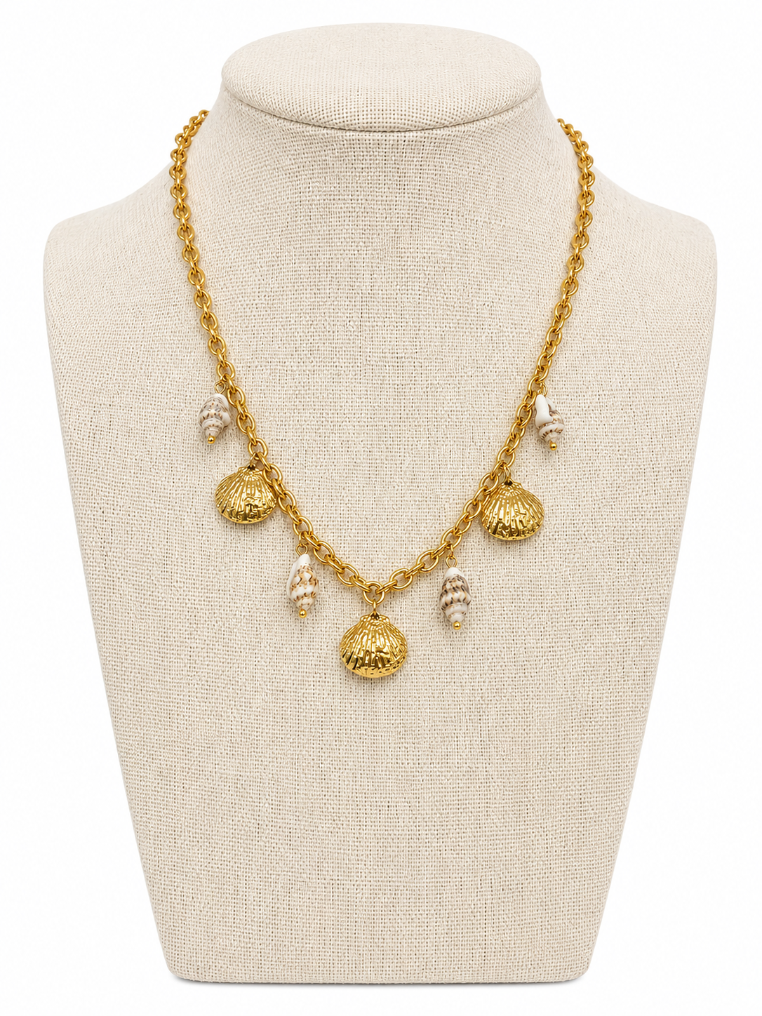 Gold charm necklace with shell pendants on a beige mannequin bust